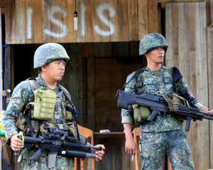 Soldiers stand guard along the main street of Mapandi village as government troops continue their assault on insurgents from the Maute group. Photo: Reuters