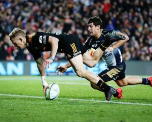 Damian McKenzie of the Chiefs scores a try against Tomas Cubelli of the Brumbies . Photo: Getty