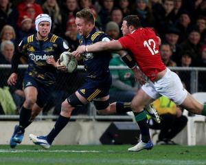 Gareth Evans slips through the tackle of Robbie Henshaw of the Lions during the Highlanders vs...