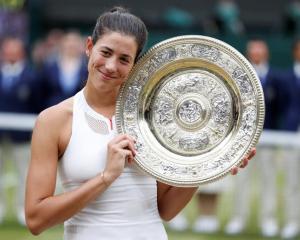 Spain’s Garbine Muguruza poses with the trophy as she celebrates winning the women's Wmbledon...