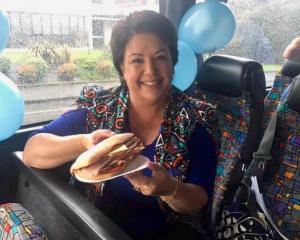 Paula shows off her panini, wearing a jacket that blends very well with the bus seats. Photo /...