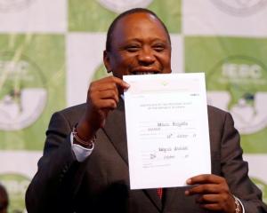 Incumbent President Uhuru Kenyatta holds the certificate of President-Elect of the Republic of...