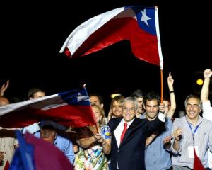 Pinera and his wife Cecilia wave flags after winning Chile's presidential election, in Santiago....