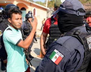 A relative argues with a police officer, near where an exchange of gunfire took place between...