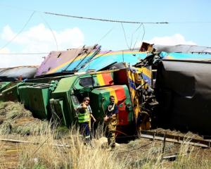 Workers stand next to a wreckage after a train crash near Hennenman in the Free State province....