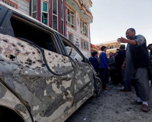 Afghan men inspect the site of a suicide bomb blast in Kabul, Afghanistan. Photo: Reuters