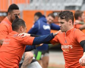 Highlanders first five-eighth Fletcher Smith (R) warms up for training with halfback Aaron Smith...