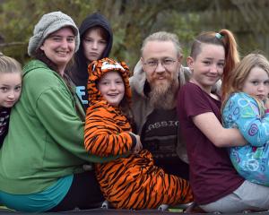 Ottley family members Morgie (9), Jen, Sam (11), Lilly (8), Garreth, Lori (12) and Soraya (7) sit...