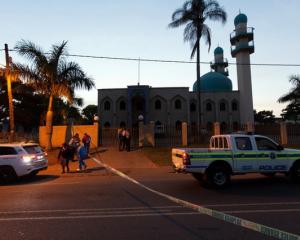 Police investigators collect evidence at a mosque where three men where attacked in Ottawa, South...