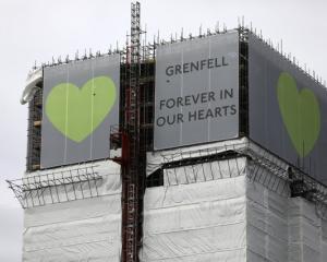 New hoarding covers the top of the Grenfell Tower to mark the first anniversary of the fire that...