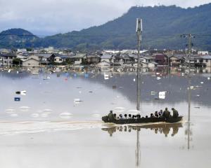 Residents are rescued from a flooded area by Japan Self-Defence Force soldiers in Kurashiki....
