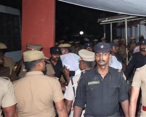 Police escort one of the men (face covered) accused of raping a 12-year girl inside the high...