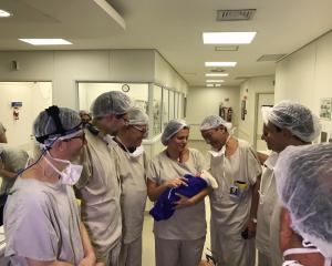 Medical team hold the first baby born via uterus transplant from a deceased donor, at the...