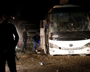 Police officers inspect a scene of a bus blast in Giza. Photo: Reuters