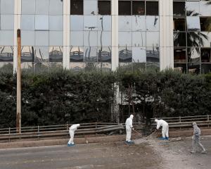 Forensic experts search for evidence after a bomb blast outside SKAI TV building in Athens. Photo...