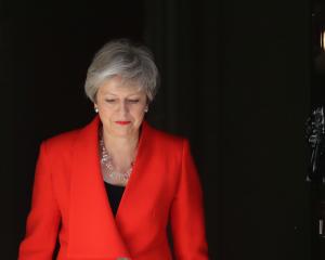 Prime Minister Theresa May, her voice cracking with emotion, said she would resign as...