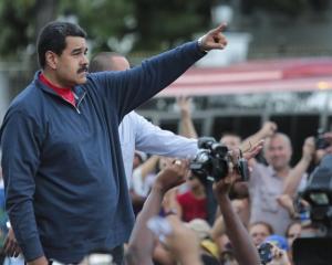 Venezuela’s President Nicolas Maduro gestures during a gathering outside Miraflores Palace in...