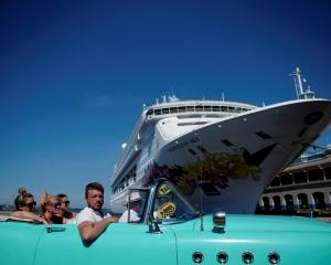 Tourists ride in a vintage car next to a cruise ship docked in Havana. Photo: Reuters