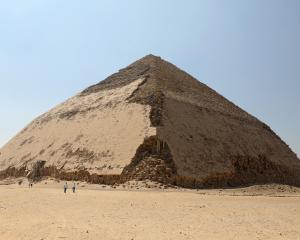 People walk in front of the Bent Pyramid of Sneferu, that was reopened after restoration work, in...