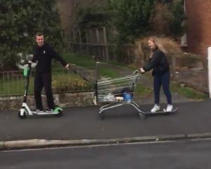 The young man rode a Lime scooter and towed a supermarket trolley behind him while a young woman on a skateboard held on to the back of the trolley. Screengrab: Gerard O'Brien