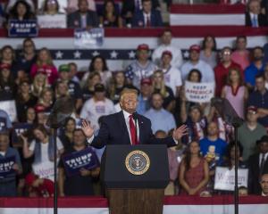 Trump grins during a rally in North Carolina in which his supporters chanted "send them back",...