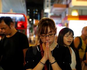 A woman pays her respects to protesters who were injured during clashes with the police, outside...