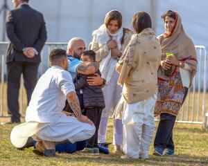 Huata Arahanga hugs five-year-old Ayaan Naeem, who lost his father and brother in the massacre on...