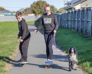 Skateboarding and exercising the dog at the Rawhiti School bike track, New Brighton.
