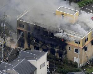 An aerial view shows firefighters battling fires at the site where a man started a fire after...