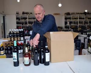 Wine Freedom co-owner Paul Williams packs a box of wine in his shop in Dunedin's Warehouse...