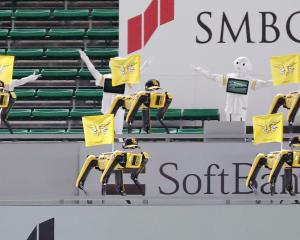 Robots cheer the team next to empty spectator seats at a baseball game between SoftBank Hawks and...