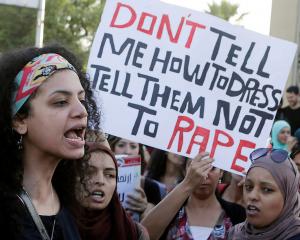 Women chant slogans as they gather to protest against sexual harassment in front of the opera...