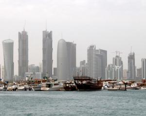 Traditional fishing Dhows are seen in port near modern glass and steel buildings on the Doha skyline. Photo: Reuters
