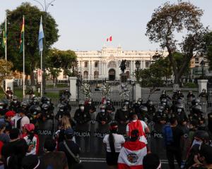 Police stand guard outside Congress after Peru's interim President Manuel Merino announced his...