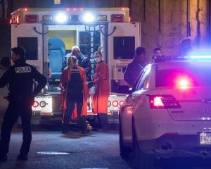 A person is treated by an ambulance crew in an area where multiple people were stabbed in Quebec...