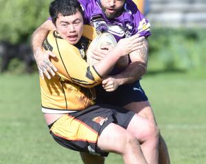 Kia Toa Tigers player Aiden Muraahi tries to escape the clutches of South Pacific Raiders...