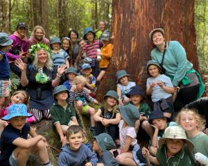 Tahu Mackenzie (left) calls kindergarten pupils visiting Orokonui 
...