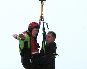Greg Clark is rescued by Dunedin Marine Search and Rescue squad member Paul Sharp from the surf...