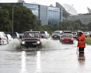 Cars attempt to negotiate flooding in Albany, Auckland after torrential rain  this week. PHOTO: NZME