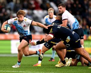 Waratahs openside flanker Michael Hooper brushes off a tackle as he powers to score his team's...