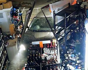 CCTV footage captured of the car ramming into the store, taking out a shelf of whiskey in the...