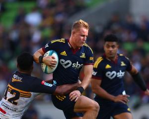 Sam Gilbert of the Highlanders is tackled during the round 10 Super Rugby Pacific match against...