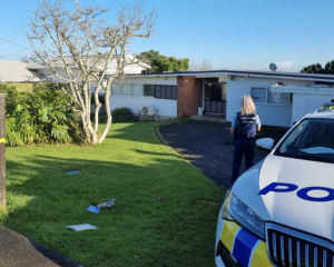 Police guard a house on Bleakhouse Rd, Mellons Bay. Photo: RNZ 