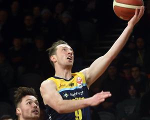 Otago Nuggets guard Darcy Knox heads to the basket to score, watched by Canterbury Rams player...