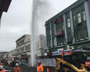 A burst water main on George St is sending water four storeys into the air. Photo: Gerard O'Brien 