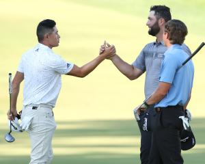 Colin Morikawa (left) and John Rahm shake hands at the end of round two of the US Open at The...