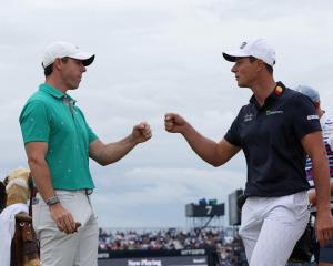 Rory McIlroy (L) and Viktor Hovland celebrate on the 10th hole after scoring an eagle and a...