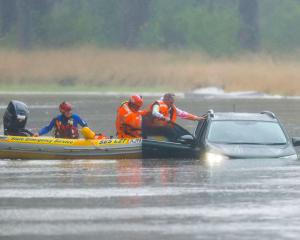 A man is rescued from a vehicle stuck in floodwaters in Windsor, northwest of Sydney. Photo: Getty