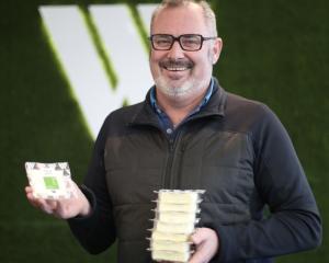 Whitestone Cheese managing director Simon Berry holds a stack of the company's Fuchsia Creek Feta...