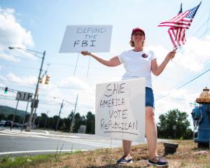 A Trump supporter makes her feelings known about the FBI near the Trump National Golf Club in...